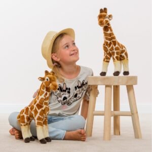 Kind speelt met grote staande giraf knuffel