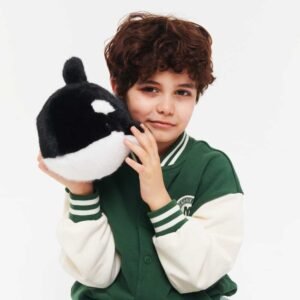 Jongen knuffelt zwarte orka walvis knuffel van pluche
