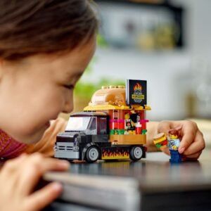 Kind speelt met LEGO City Hamburgertruck 60404 en minifiguur
