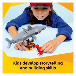 Kind speelt met LEGO Creator Woeste Haai en schatkist
