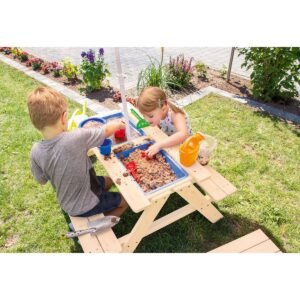 Close-up van zand- en watertafel met speelgoed en bakjes in modderbank