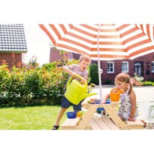 Kinderen spelen met gieter en water aan modderbank onder parasol in tuin