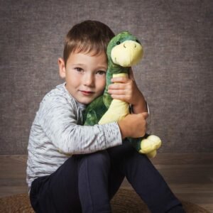 Kind knuffelt zachte groene dinosaurus knuffel