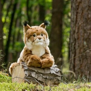 Pluche lynx knuffel liggend op een boomstam in een bosrijke omgeving