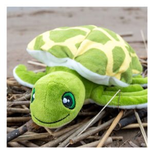 Groene zeeschildpad knuffel op het strand tussen natuurlijk drijfhout