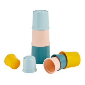 Pastel gekleurde stapelbekers speelgoed toren met losse bekers op witte achtergrond