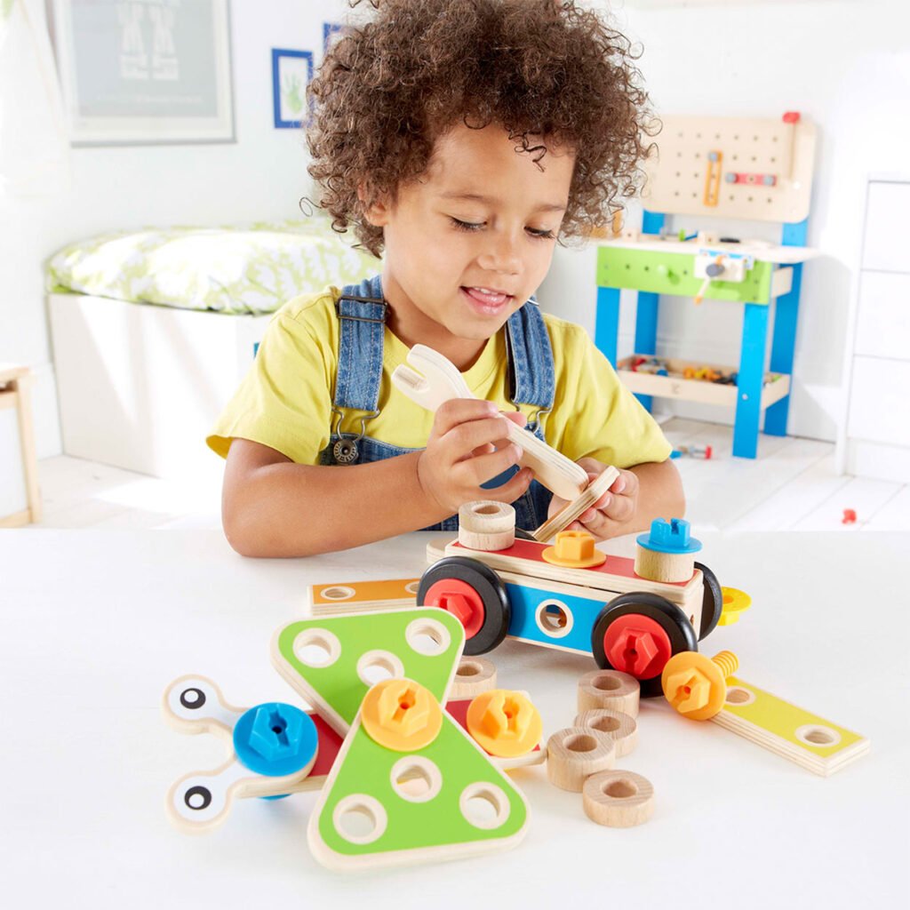 Kind monteert houten constructiespeelgoed met speelgoedgereedschap Hape Bouwset Basic