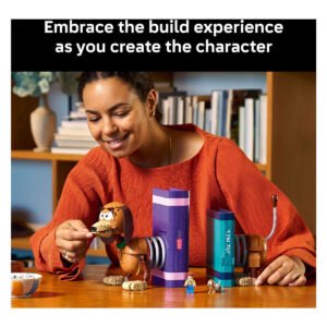 Persoon bouwt LEGO Disney Toy Story Slinky Hond boekensteunen