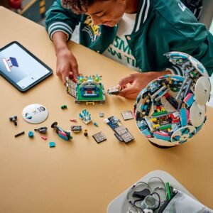 Kind bouwt LEGO voetbal met losse onderdelen op tafel