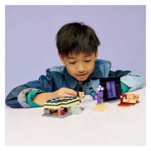 Jongen met de LEGO Minecraft 21584 Reis naar de Nether en Eind-portaal aan tafel