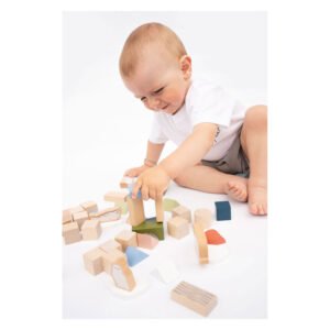 Toddler playing with wooden building blocks on white studio background